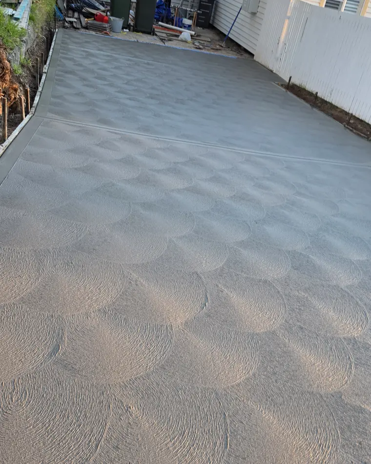 Patterned decorative concrete driveway beside a residential home